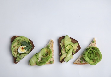 Flat lay composition with crisp avocado toasts on white background