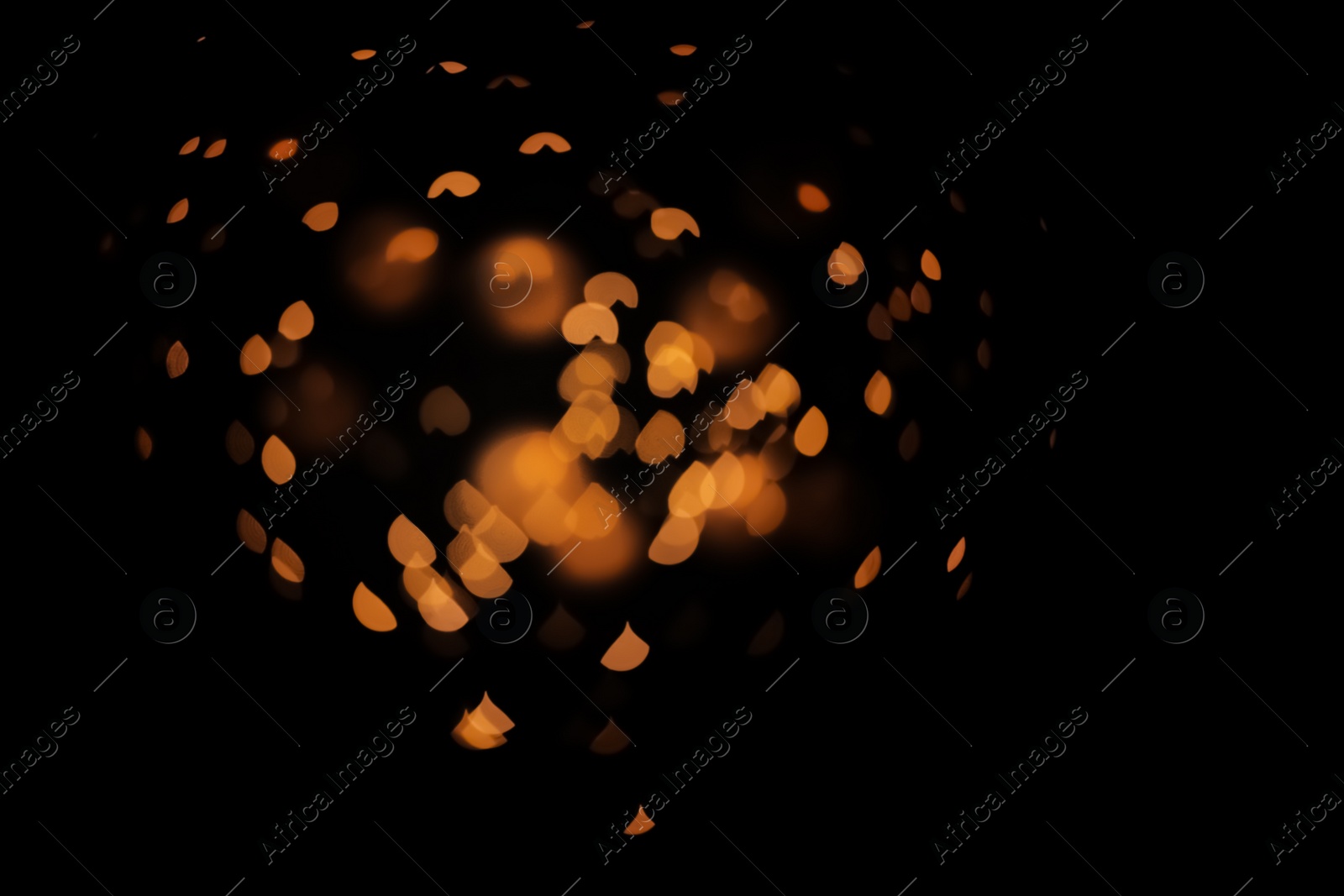 Photo of Blurred view of gold lights on dark background. Bokeh effect