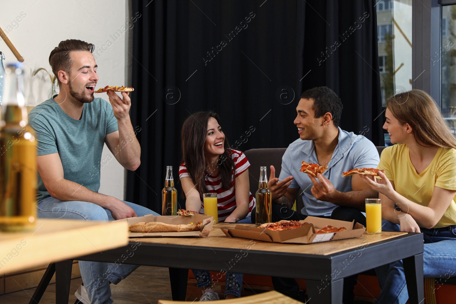 Photo of Group of friends having fun party with delicious pizza in cafe