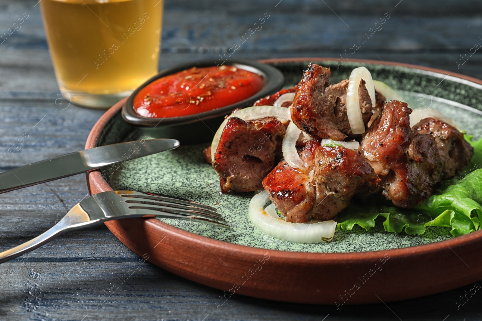 Photo of Plate with shish kebab and sauce on table, closeup