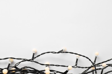 Photo of Beautiful Christmas lights on white background, top view