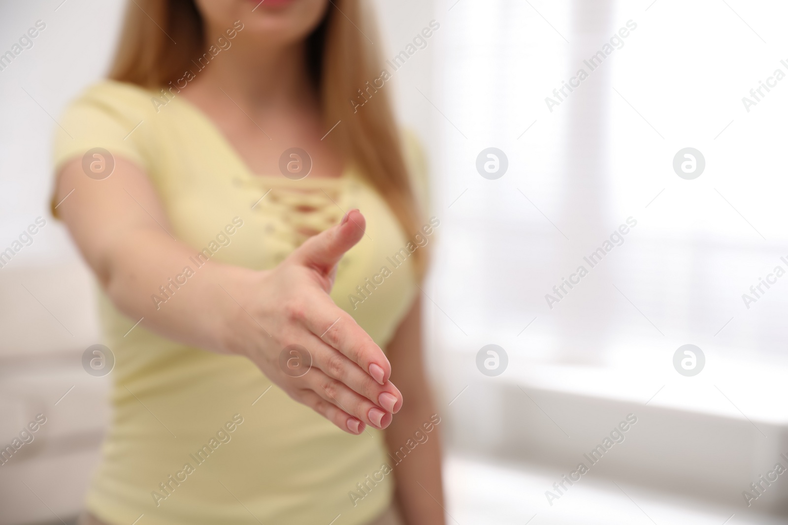 Photo of Woman offering handshake indoors, closeup. Space for text