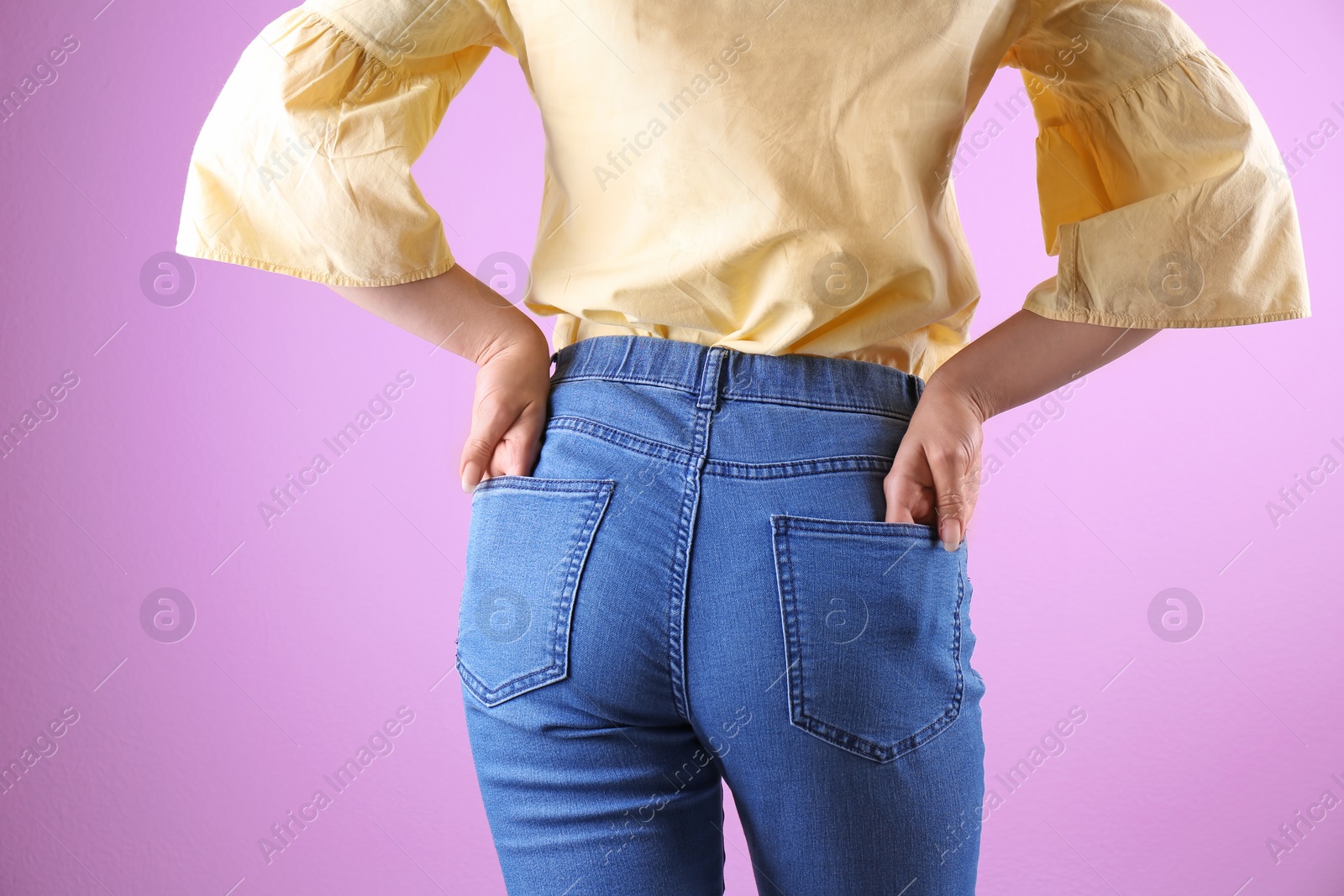 Photo of Woman in stylish blue jeans on color background