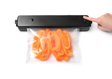 Photo of Woman using sealer for vacuum packing with plastic bag of bell pepper on white background, above view