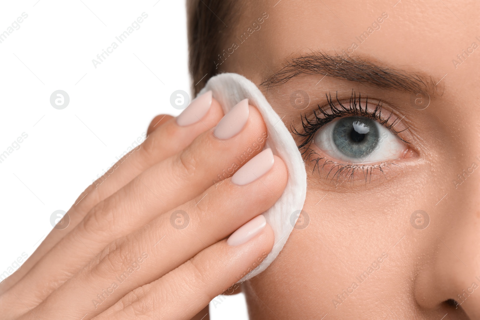 Photo of Woman removing makeup with cotton pad on white background, closeup