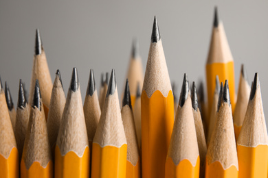 Photo of Many graphite pencils on grey background, closeup