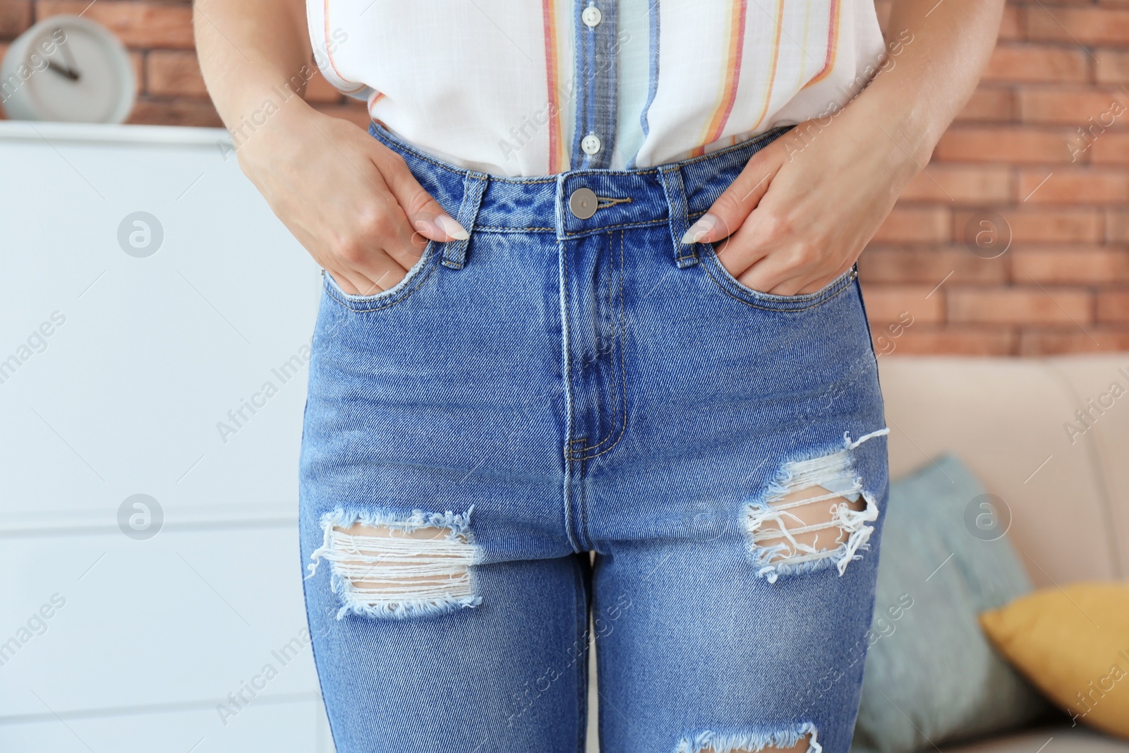 Photo of Young woman in stylish blue jeans indoors