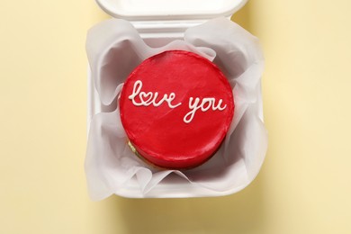 Photo of Bento cake with Love You text in takeaway box on beige table, top view. St. Valentine's day surprise