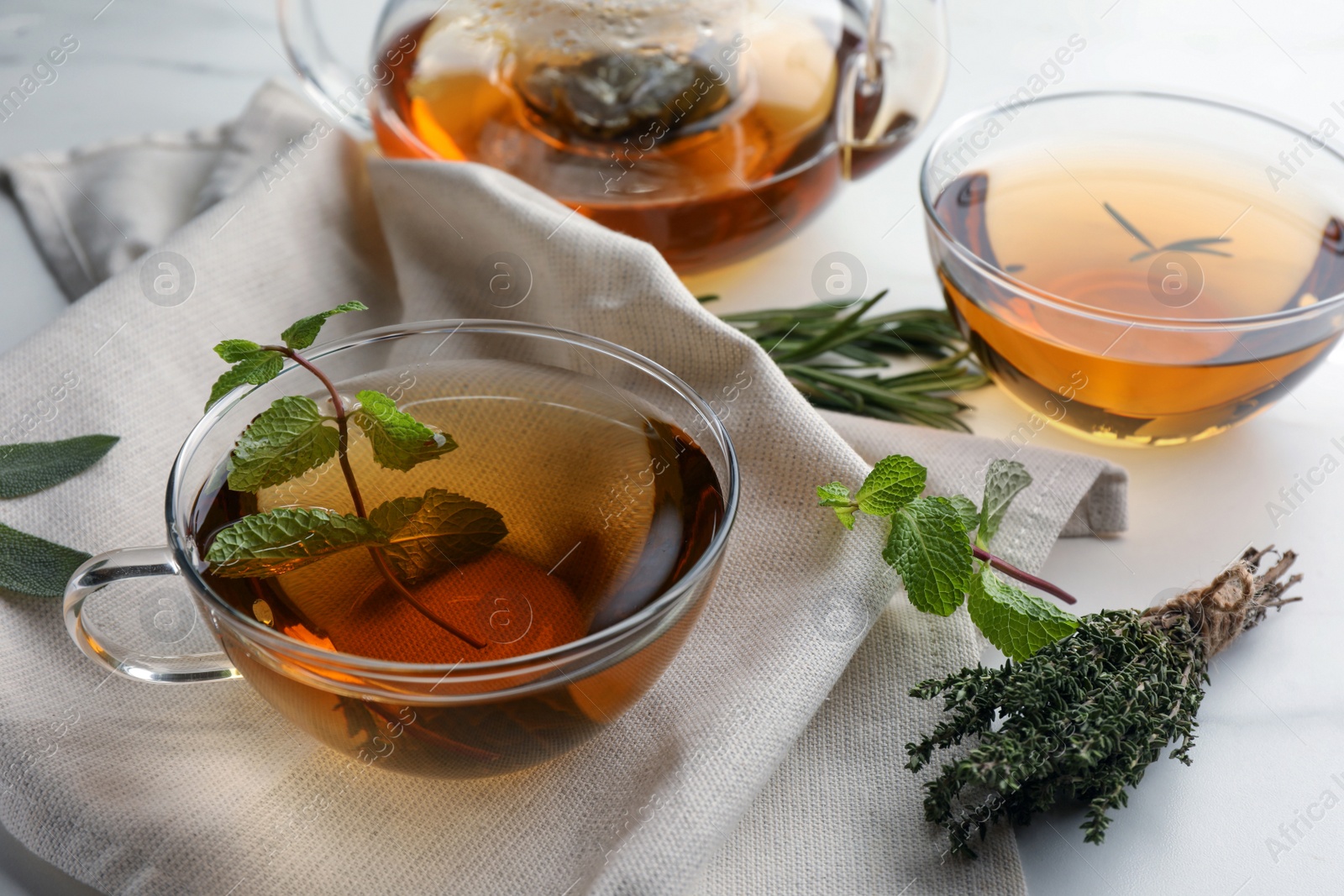 Photo of Aromatic herbal tea with rosemary, sage, thyme and mint on table