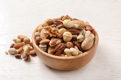 Photo of Bowl with organic mixed nuts on wooden table