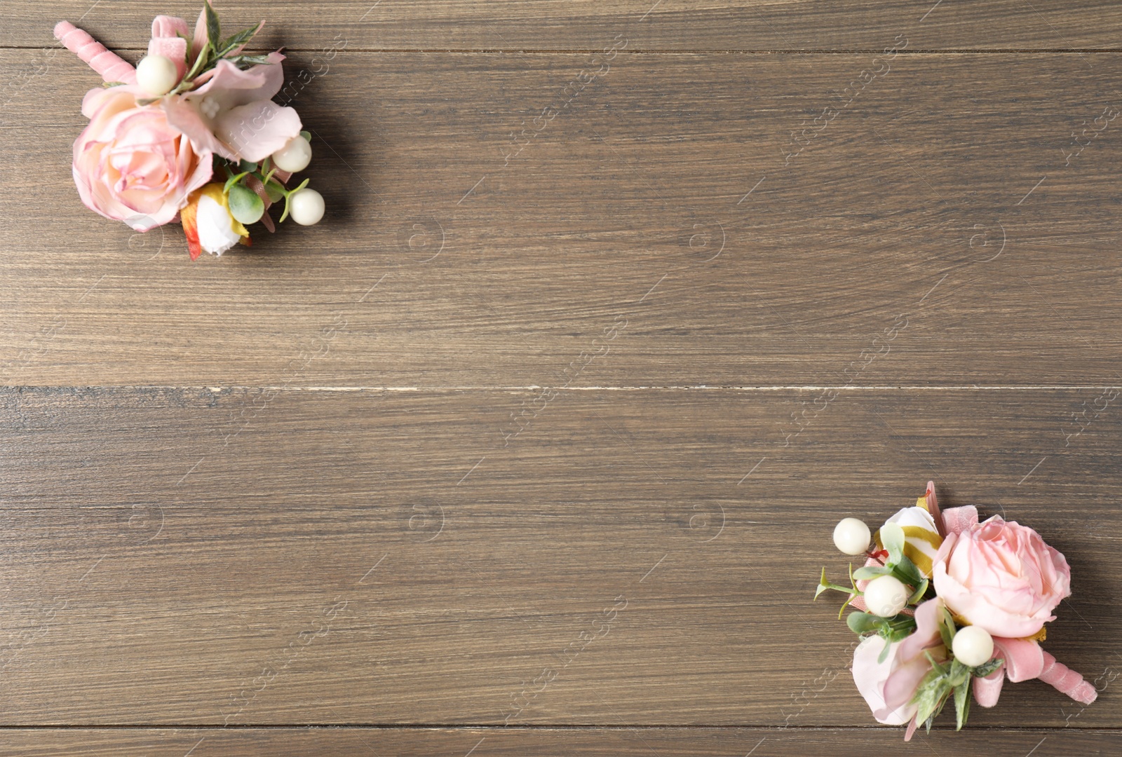 Photo of Beautiful boutonnieres on wooden background, flat lay. Space for text