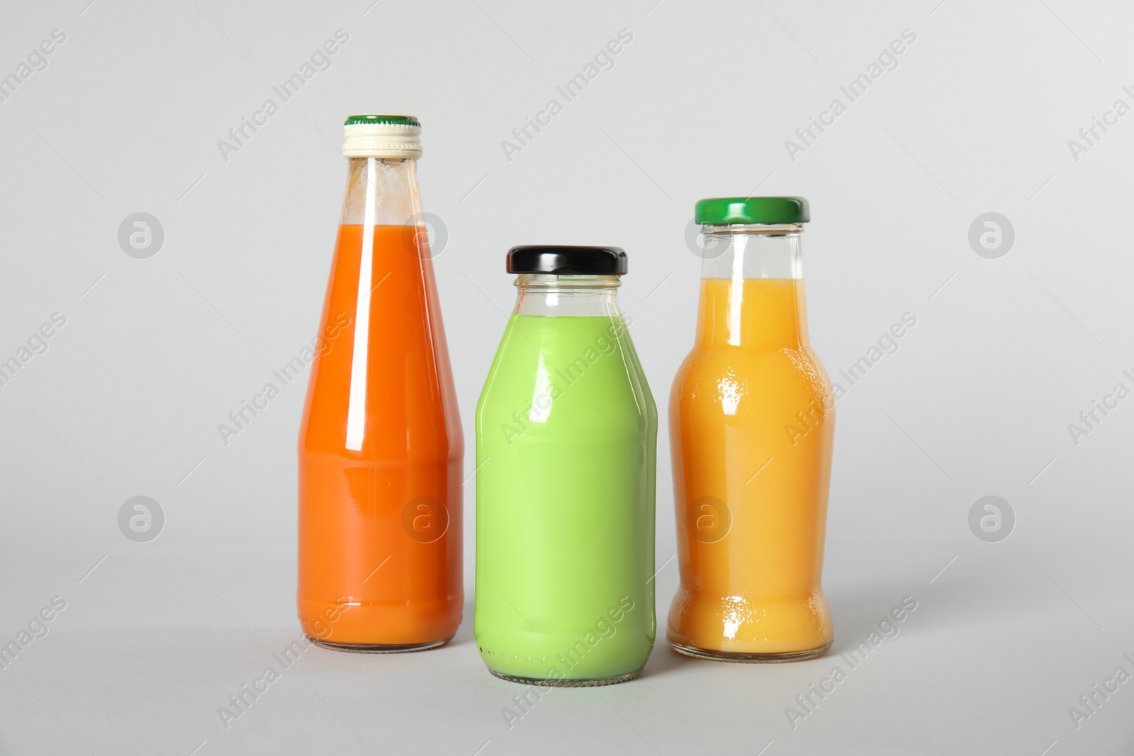 Photo of Bottles with different drinks on color background