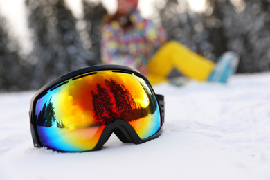 Stylish ski goggles on snow outdoors. Winter sport equipment