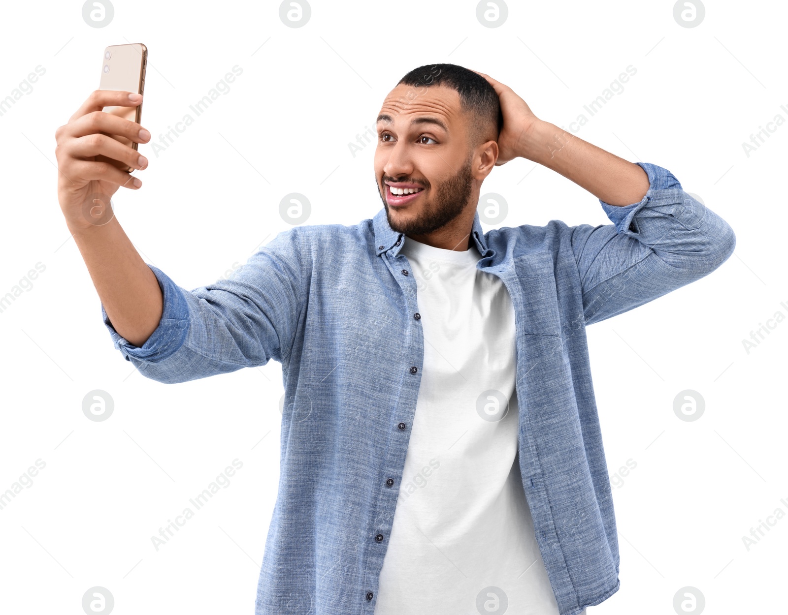 Photo of Smiling young man taking selfie with smartphone on white background