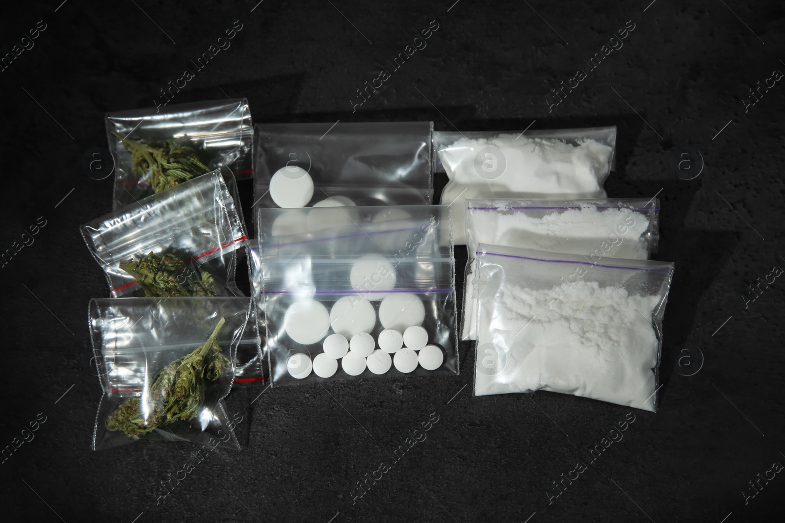 Photo of Cocaine, dried hemp and ecstasy on dark table, top view