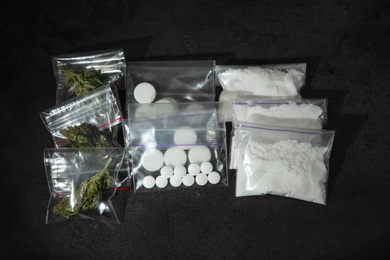 Photo of Cocaine, dried hemp and ecstasy on dark table, top view