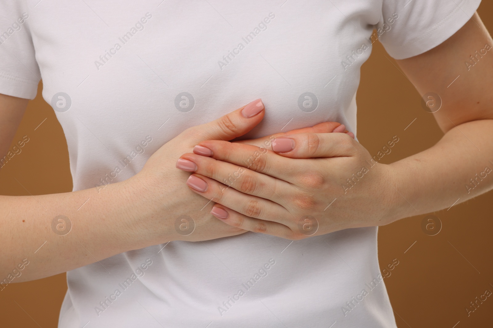 Photo of Woman having heart attack on brown background, closeup