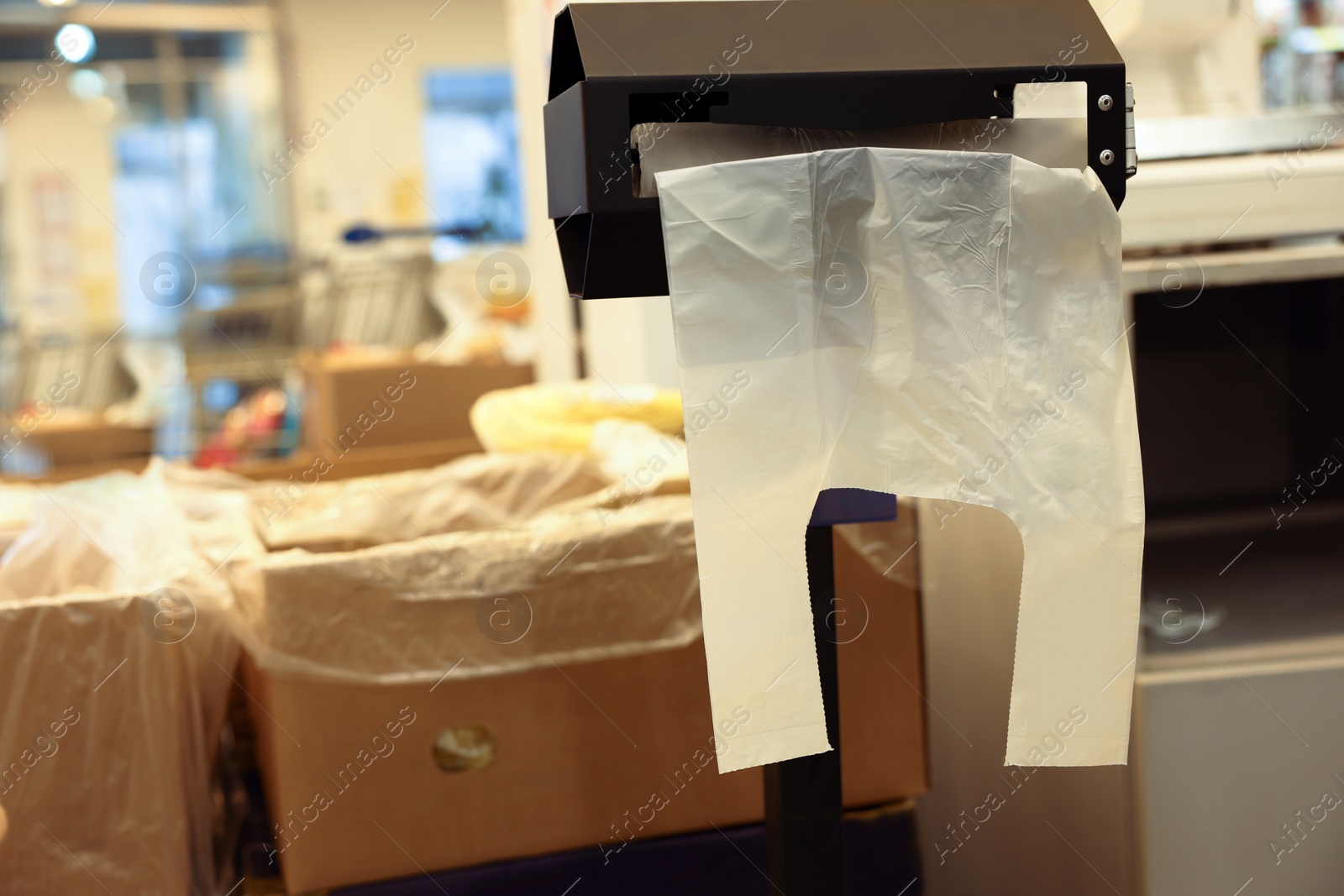 Photo of Plastic bags near boxes with products in supermarket, space for text