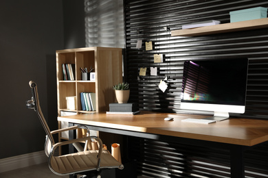 Photo of Comfortable workplace with office chair and computer on wooden table