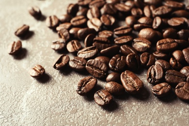 Roasted coffee beans on grey background, closeup