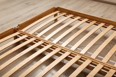 Photo of Wooden bed frame on floor, closeup view