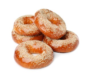 Many delicious fresh bagels on white background
