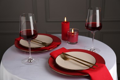 Photo of Place setting with candles on white table. Romantic dinner