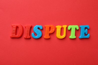 Word Dispute made of colorful letters on red background, flat lay