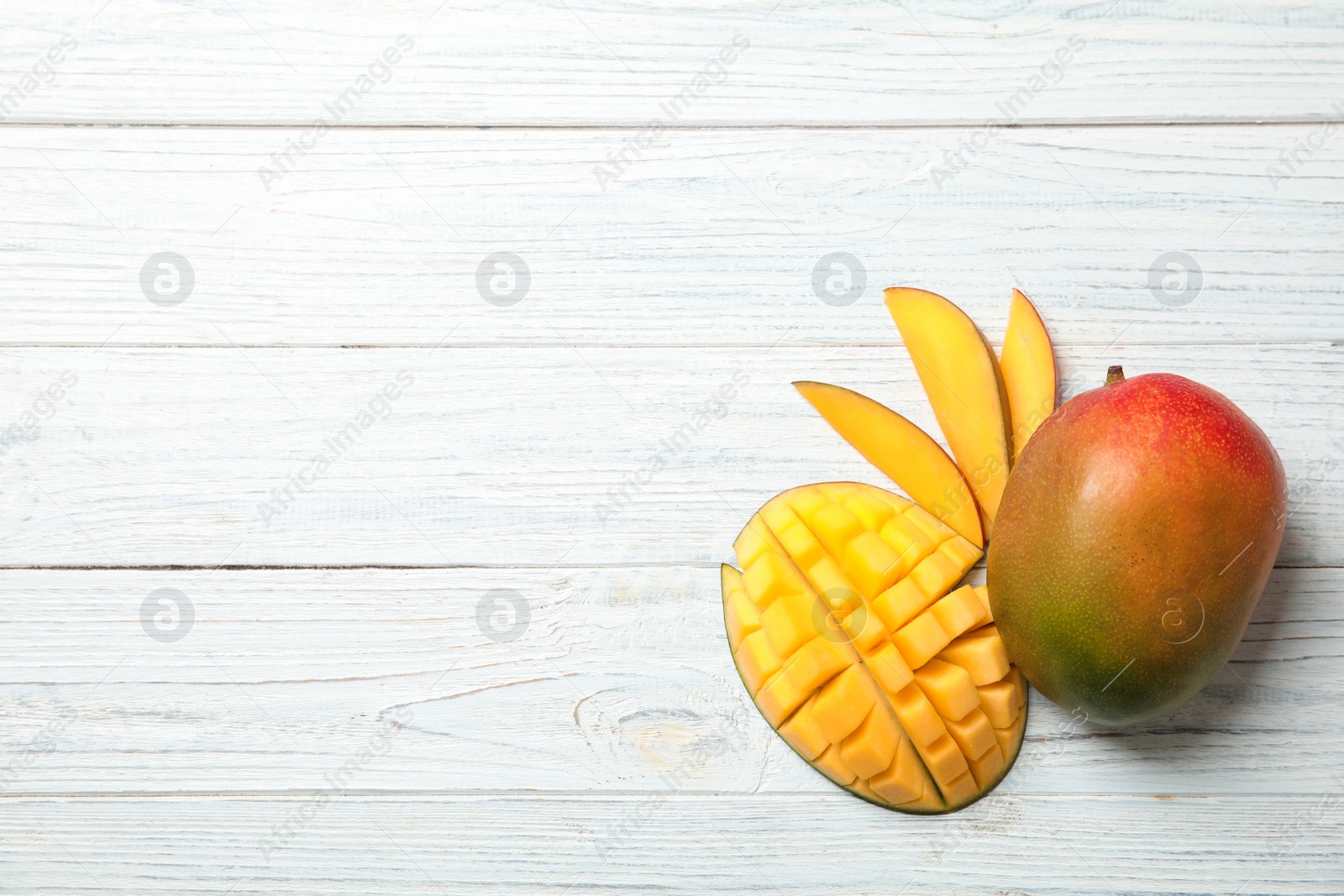 Photo of Flat lay composition with ripe mangoes and space for text on white wooden background