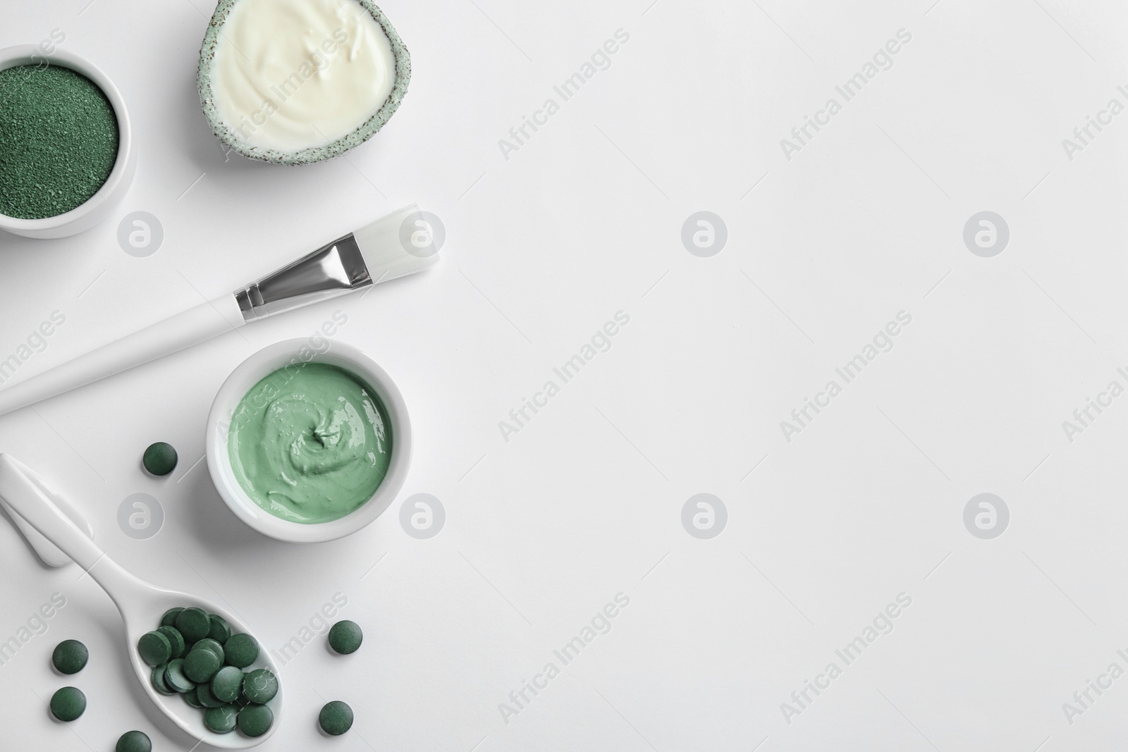 Photo of Composition with spirulina facial mask and ingredients on white background, top view