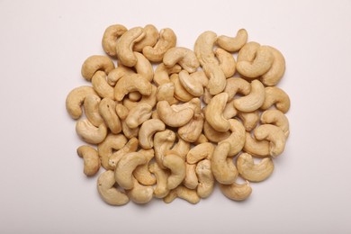 Photo of Pile of tasty cashew nuts on white background, top view