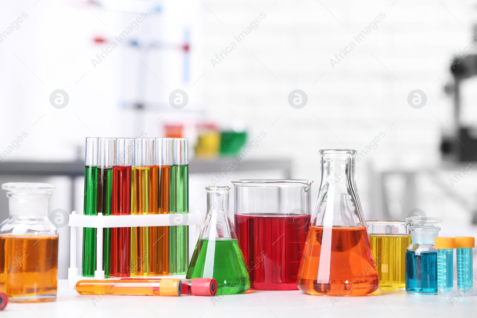 Photo of Different glassware with samples on table in chemistry laboratory