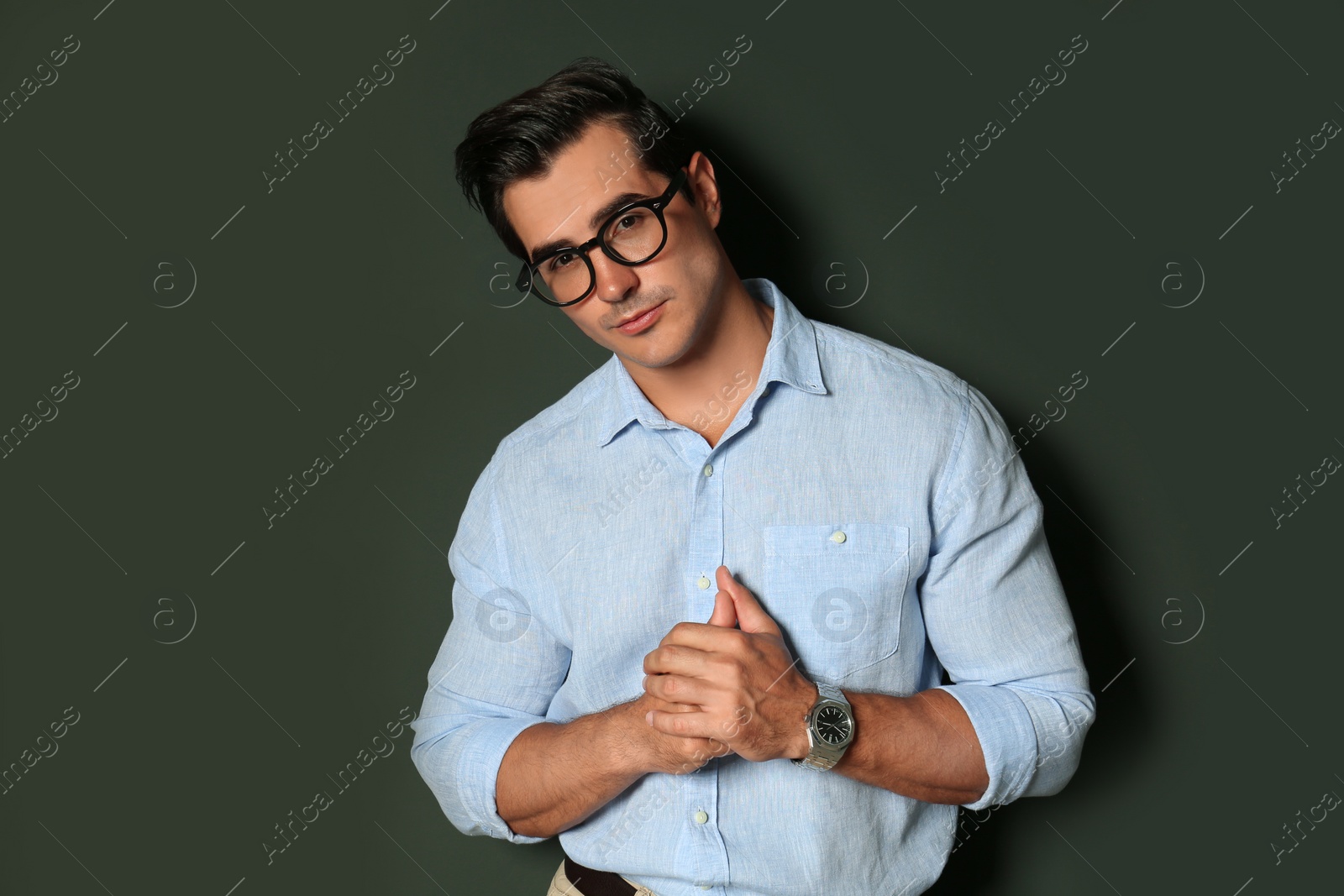 Photo of Handsome young man in stylish clothes with glasses on dark background