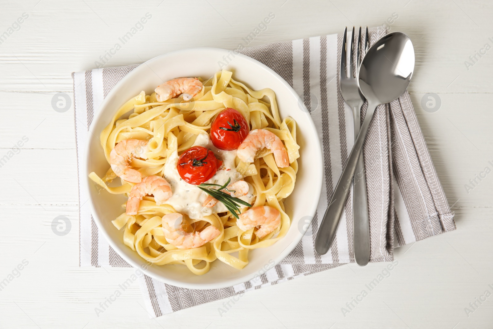Photo of Delicious pasta with shrimps served on white wooden table, top view