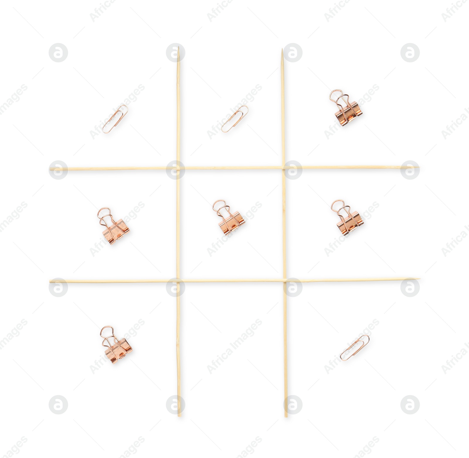 Photo of Tic tac toe game made with paper clips isolated on white, top view