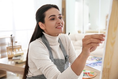 Young woman drawing on canvas in studio