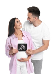 Happy young family with ultrasound picture on white background