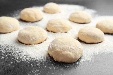 Photo of Raw wheat dough and flour on grey table