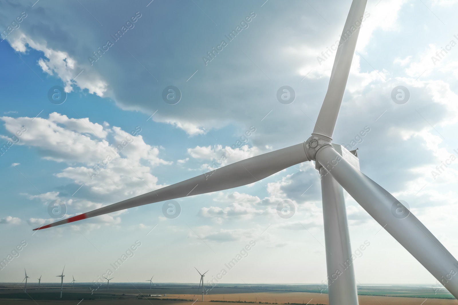 Photo of Modern windmill against sky with clouds, closeup. Energy efficiency