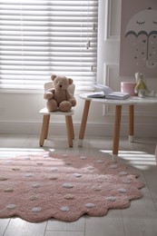 Round pink rug on floor in children's room