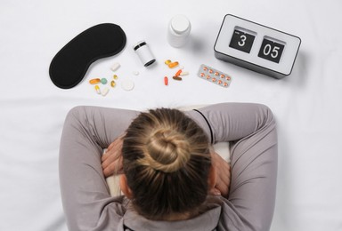 Photo of Woman surrounded by different pills on white bedsheet, top view. Insomnia treatment