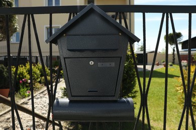 Black metal letter box on fence outdoors