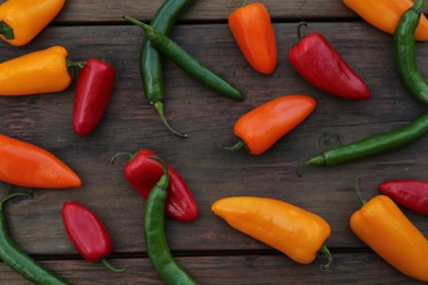 Photo of Different ripe bell peppers on wooden table, flat lay