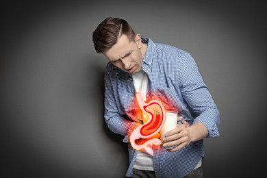 Image of Man with glass of milk suffering from heartburn on grey background. Stomach with hot chili pepper symbolizing acid indigestion, illustration