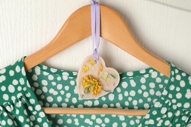 Photo of Scented sachet with flowers and stylish clothes on hanger