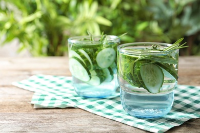 Photo of Natural lemonade with cucumber in glasses on table