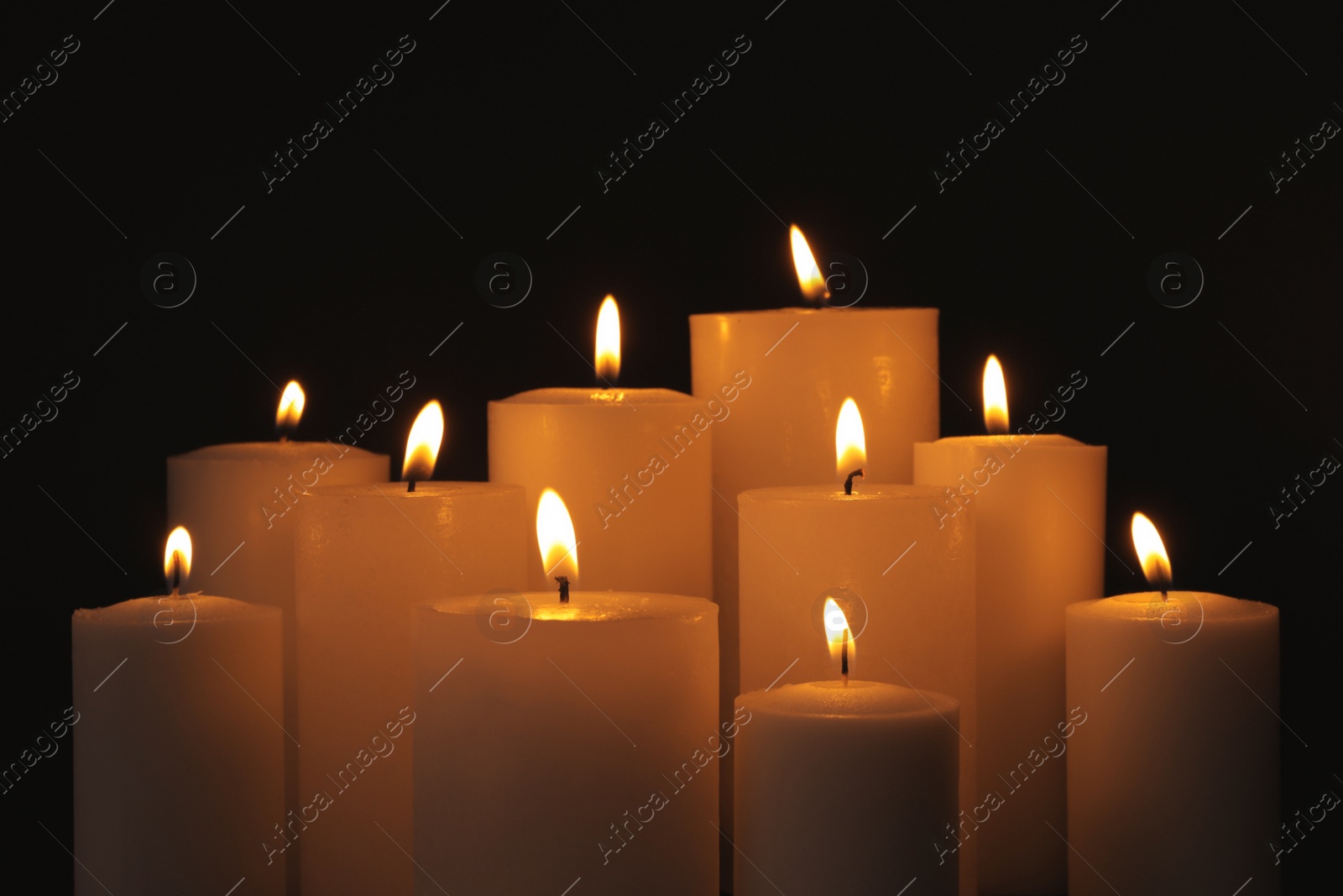 Photo of Burning candles on dark background. Symbol of sorrow