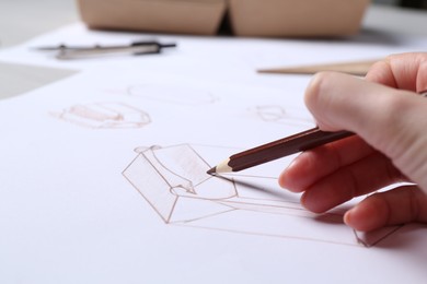 Photo of Woman creating packaging design at table, closeup