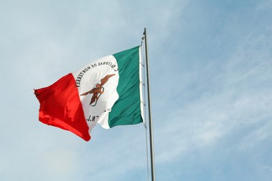 Mexico flag fluttering against blue sky on sunny day