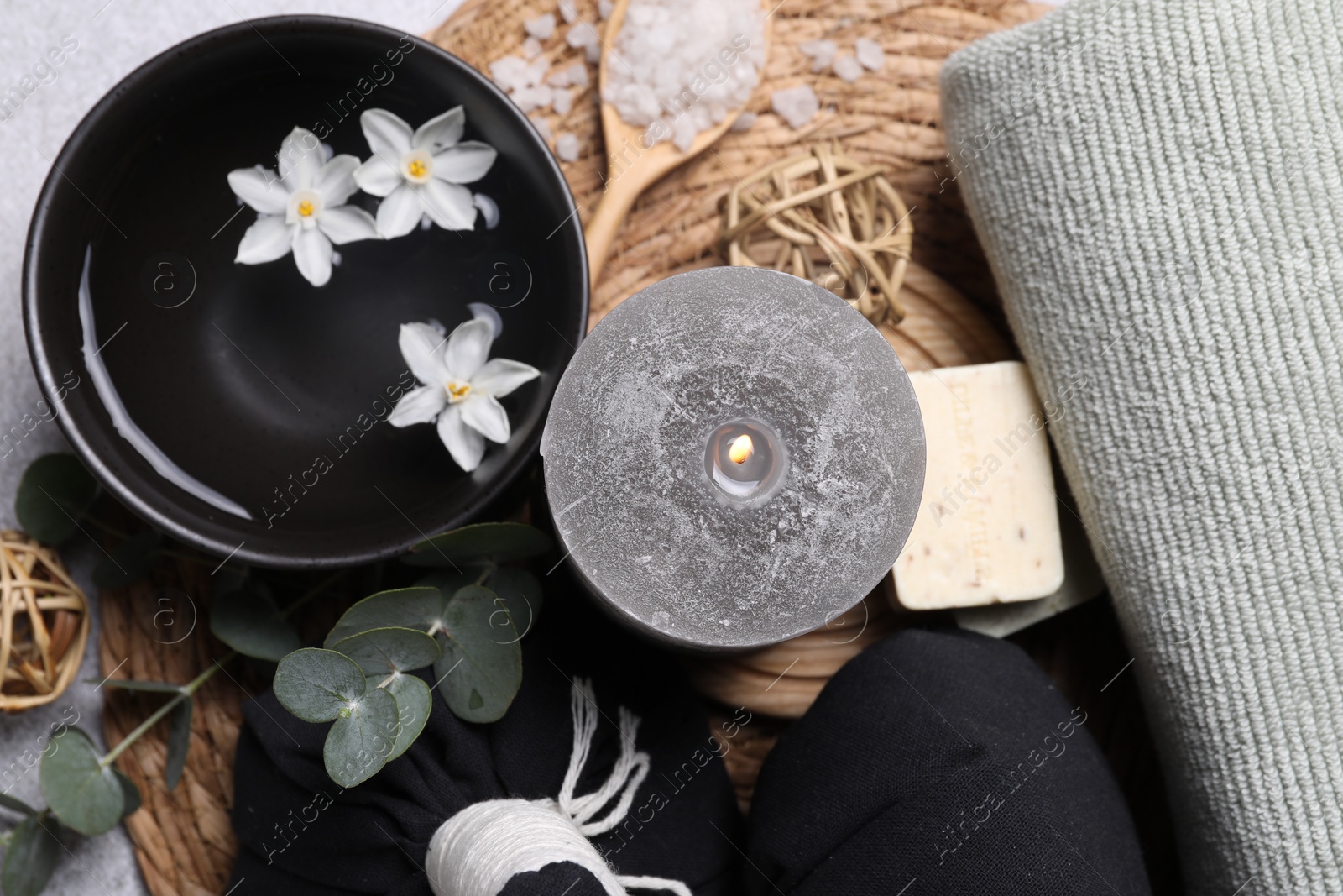 Photo of Flat lay composition with herbal massage bags, spa products and flowers on light grey table